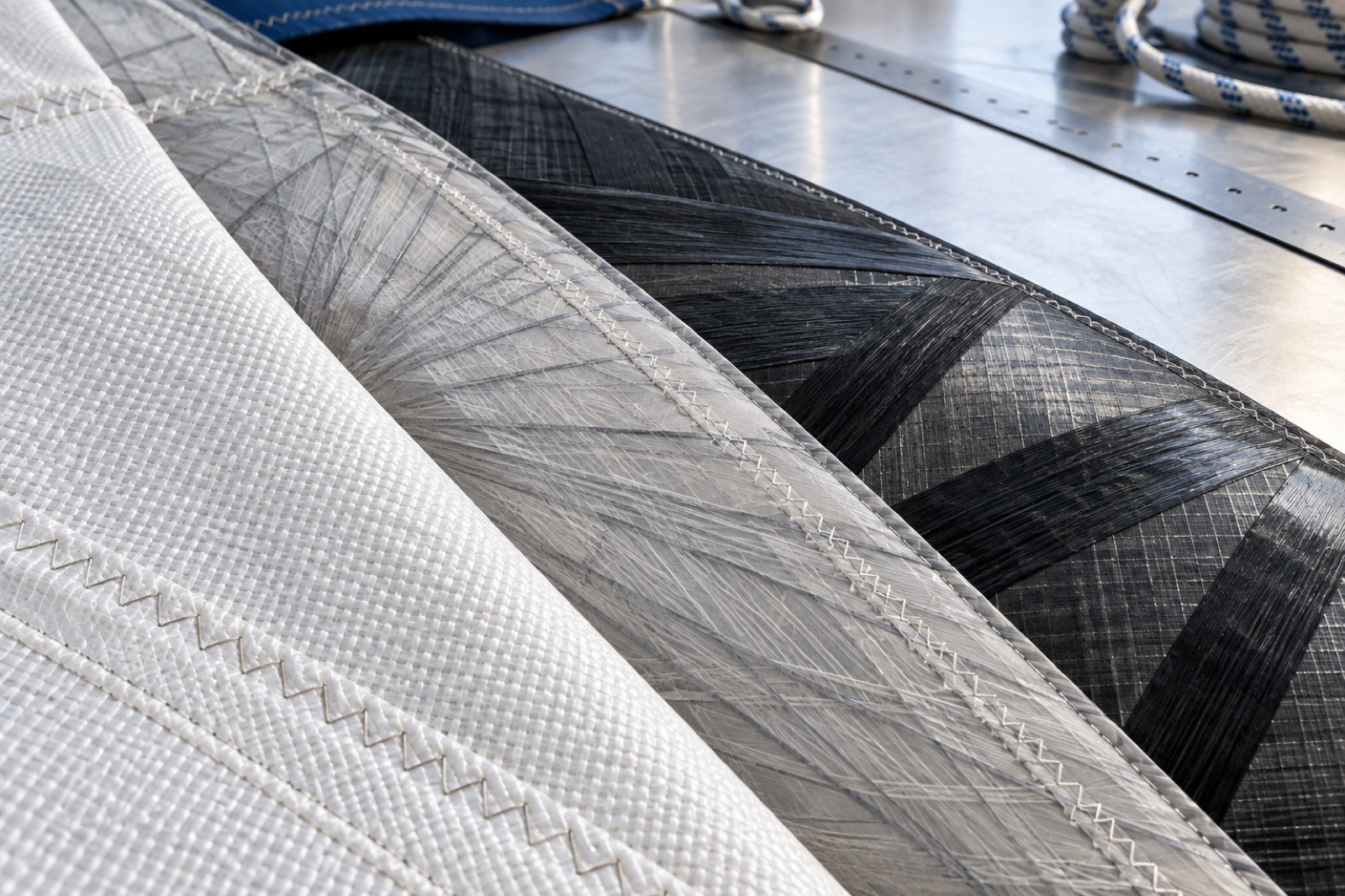 Illustrative woven, laminate and load-path yacht sail materials on a sail loft workbench